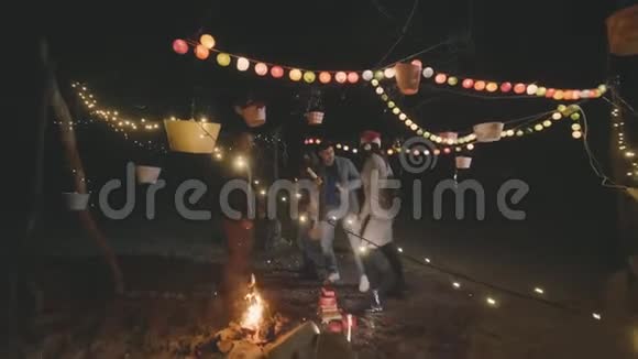 朋友们在海滩篝火旁庆祝圣诞节视频的预览图