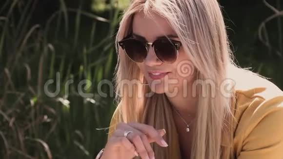公园里戴着墨镜的金发美女视频的预览图