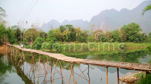 通过竹桥摩托车石灰石景观老挝视频的预览图