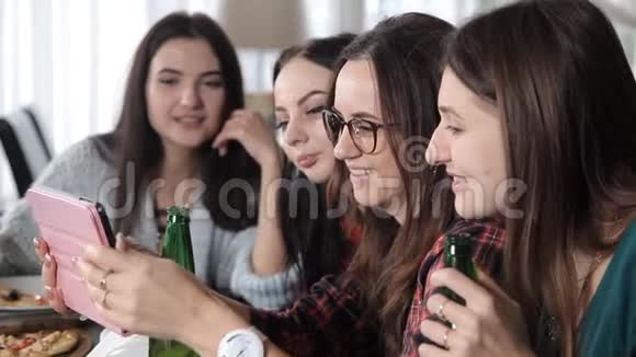 几个女孩吃比萨饼喝啤酒瓶在餐厅开怀大笑庆祝视频的预览图