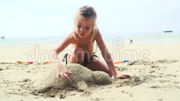 泰国沙滩上玩沙子的金发女孩视频的预览图