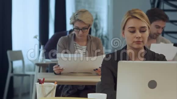 在现代办公室用笔记本电脑工作的年轻女性视频的预览图