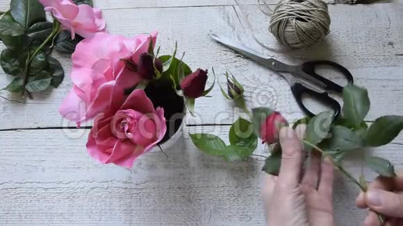 女性装饰师在木桌上布置玫瑰的俯视图视频的预览图