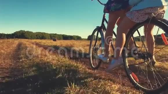母亲和女儿骑自行车在草地上家庭在大自然中骑自行车家的概念视频的预览图