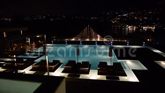 豪华酒店配有夜间照明喷泉的游泳池视频的预览图