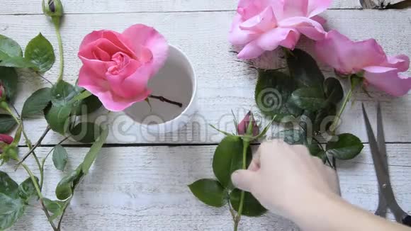 女性装饰师在木桌上布置玫瑰的俯视图视频的预览图