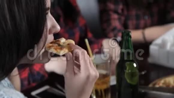 几个女孩吃比萨饼喝啤酒瓶在餐厅开怀大笑庆祝视频的预览图