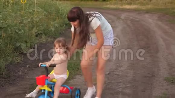妈妈教女儿骑自行车姐姐和一个小孩子玩快乐童年的概念一个小孩学视频的预览图