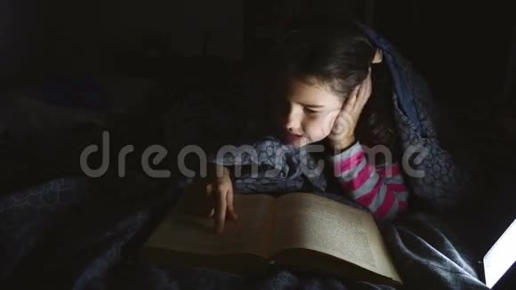 十几岁的女孩用手电筒躺在毯子下面看书视频的预览图
