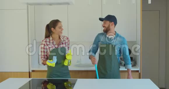 男人和女人作为一个专业的清洁工在厨房工作期间玩得很开心视频的预览图
