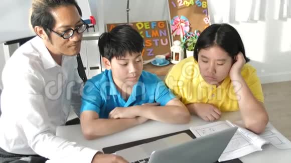 辅导教室里的孩子和老师在笔记本电脑上学习视频的预览图
