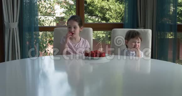 可爱的孩子在家吃新鲜成熟的草莓视频的预览图