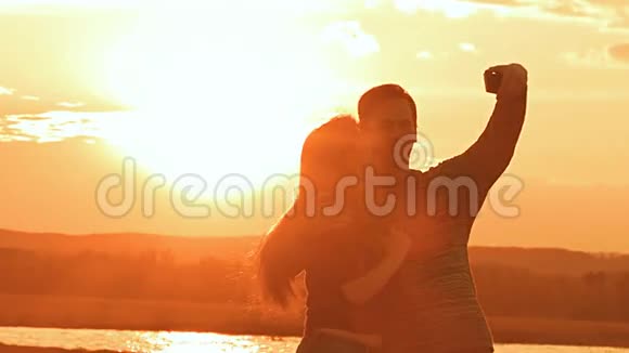 日落时分男人和女人拥抱慢动作视频视频的预览图