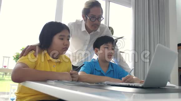 辅导教室里的孩子和老师在笔记本电脑上学习视频的预览图