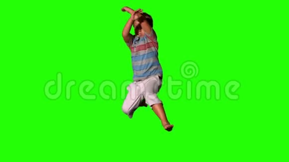 男孩在绿色的屏幕上跳跃视频的预览图