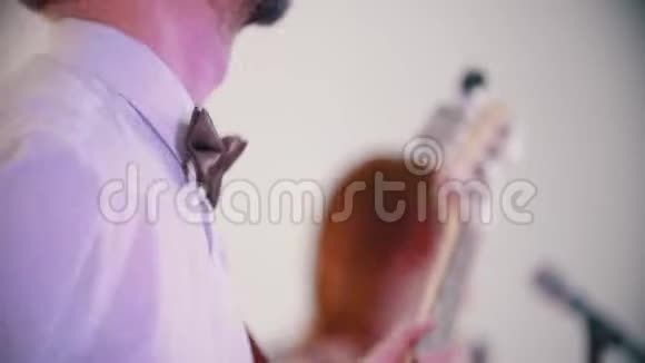 一支演奏歌曲的音乐乐队一个演奏低音吉他的男人视频的预览图