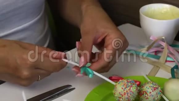 一个女人在盘子里装饰辫子蛋糕的蝴蝶结装饰着调料的糖果视频的预览图