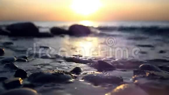 在美丽的日落中卵石滩和海浪视频的预览图