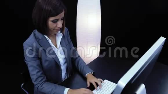 女人在电脑前工作出示一张带有文字的卡片视频的预览图