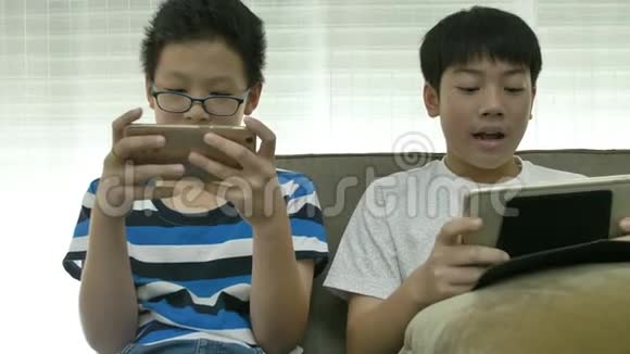 年轻的亚裔男孩玩智能手机游戏视频的预览图