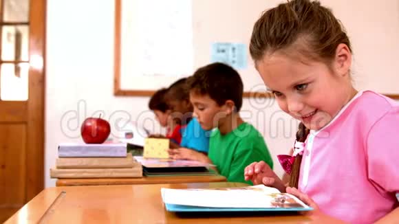 可爱的小女孩在教室里看书视频的预览图