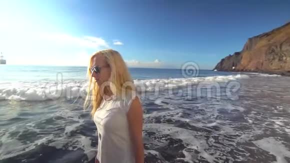 女人沿着海滩散步视频的预览图