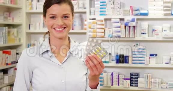 微笑的药剂师在药房展示药物视频的预览图