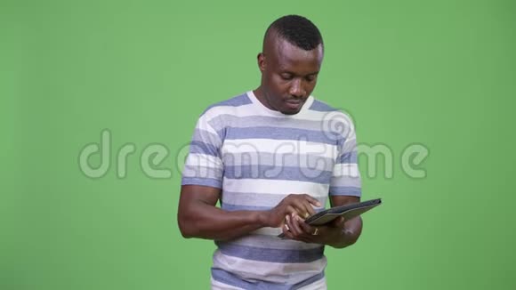 年轻快乐的非洲男人用数码平板电脑思考视频的预览图