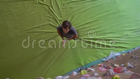 年轻人正在一个巨石攀爬健身房里爬墙视频的预览图