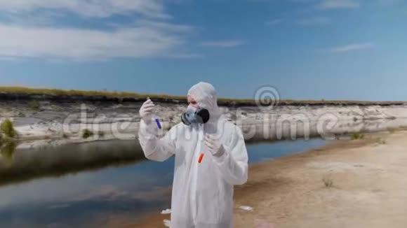 穿着防护服和呼吸器的人观察试管中水的化学反应视频的预览图