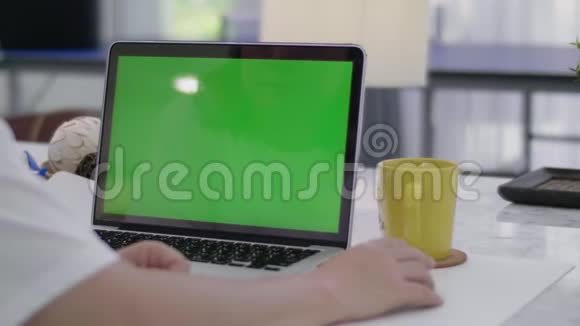在家工作的女人拿着笔记本电脑绿屏视频的预览图