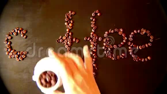 妇女在桌上用咖啡豆制成的棺材铭文视频的预览图