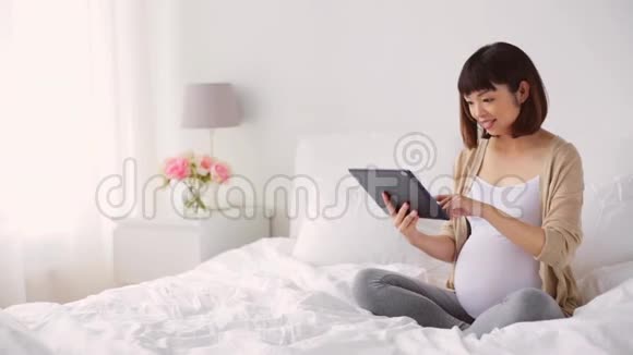 快乐的亚洲孕妇带平板电脑回家视频的预览图