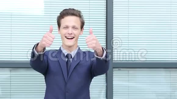 青年商人用双手举起大拇指视频的预览图
