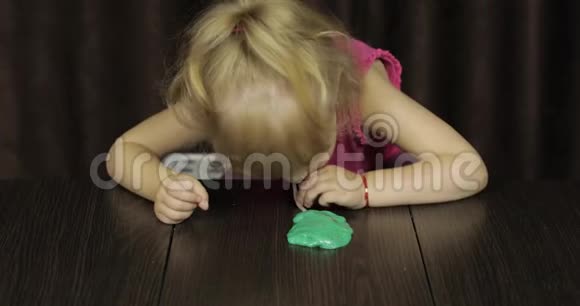 孩子们玩着做绿色黏液小孩玩手工制作的玩具黏液视频的预览图