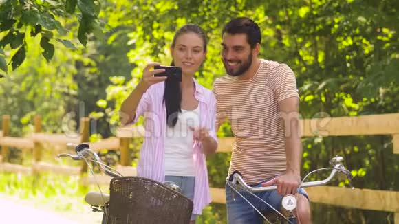 一对骑自行车的情侣用智能手机自拍视频的预览图