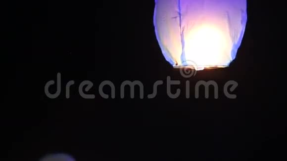 新娘和新郎在海滩上点燃了一盏中国灯笼视频的预览图
