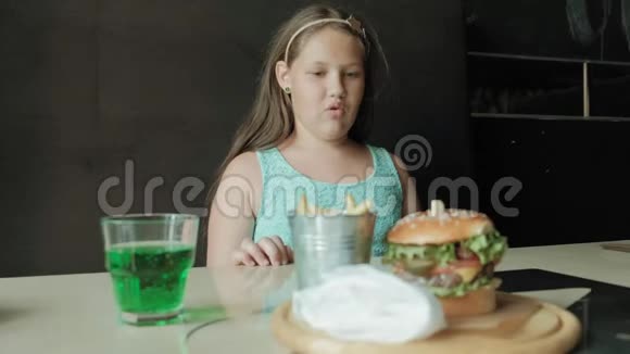 胖女孩急切地吃汉堡包健康饮食的概念视频的预览图