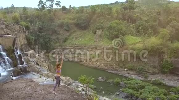 有瀑布的图案景观和岩石上的女孩视频的预览图