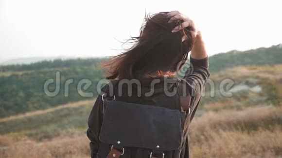日落时分年轻的徒步旅行者女孩背着背包在山顶上生活方式旅行理念视频的预览图