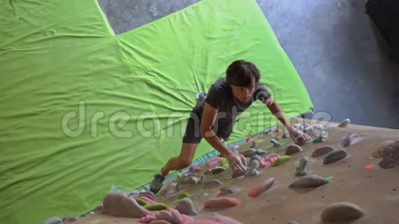 年轻人正在一个巨石攀爬健身房里爬墙视频的预览图