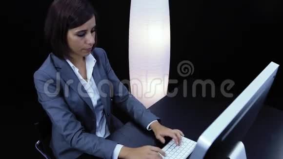 女人在电脑前工作出示一张带有文字的卡片视频的预览图