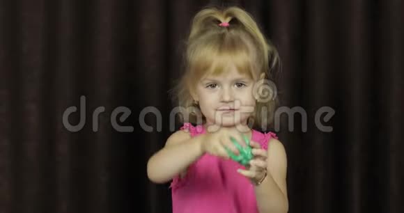 孩子们玩着做绿色黏液小孩玩手工制作的玩具黏液视频的预览图