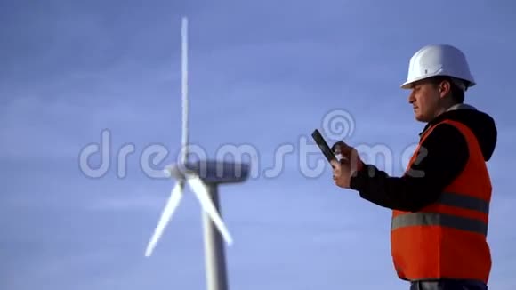 风车能源工程师在日落时与平板电脑合作环境视频的预览图