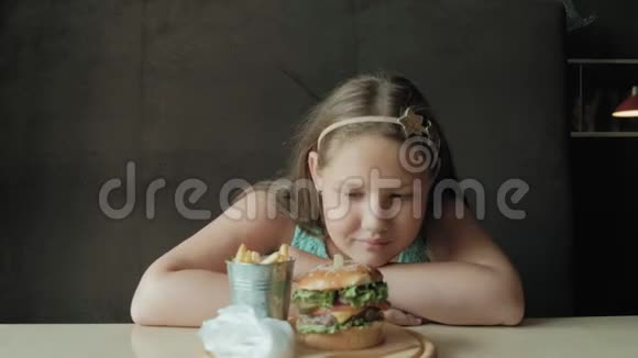 胖女孩急切地吃汉堡包健康饮食的概念视频的预览图