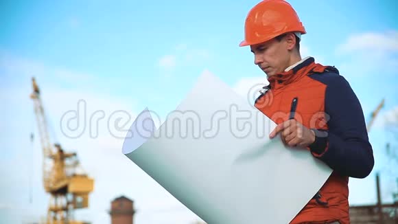 建筑工人在工地上咨询人们手里拿着蓝图生活方式建设视频的预览图