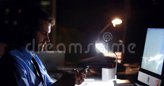 商务人员晚上使用智能手机和电脑视频的预览图