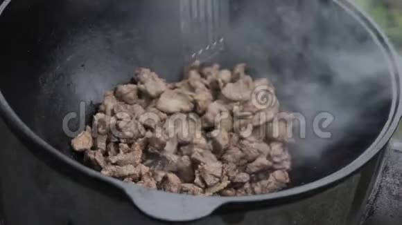 用羊肉和洋葱在木炉上的大锅里煮牛肉视频的预览图