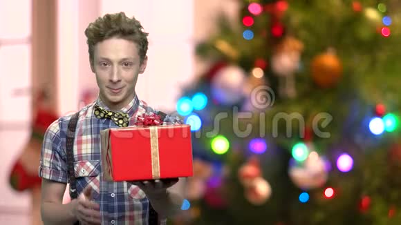 在模糊的圣诞背景上带礼物盒的男孩视频的预览图