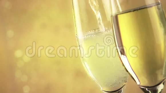 在金色的薄纱背景下用金色的气泡填满香槟视频的预览图